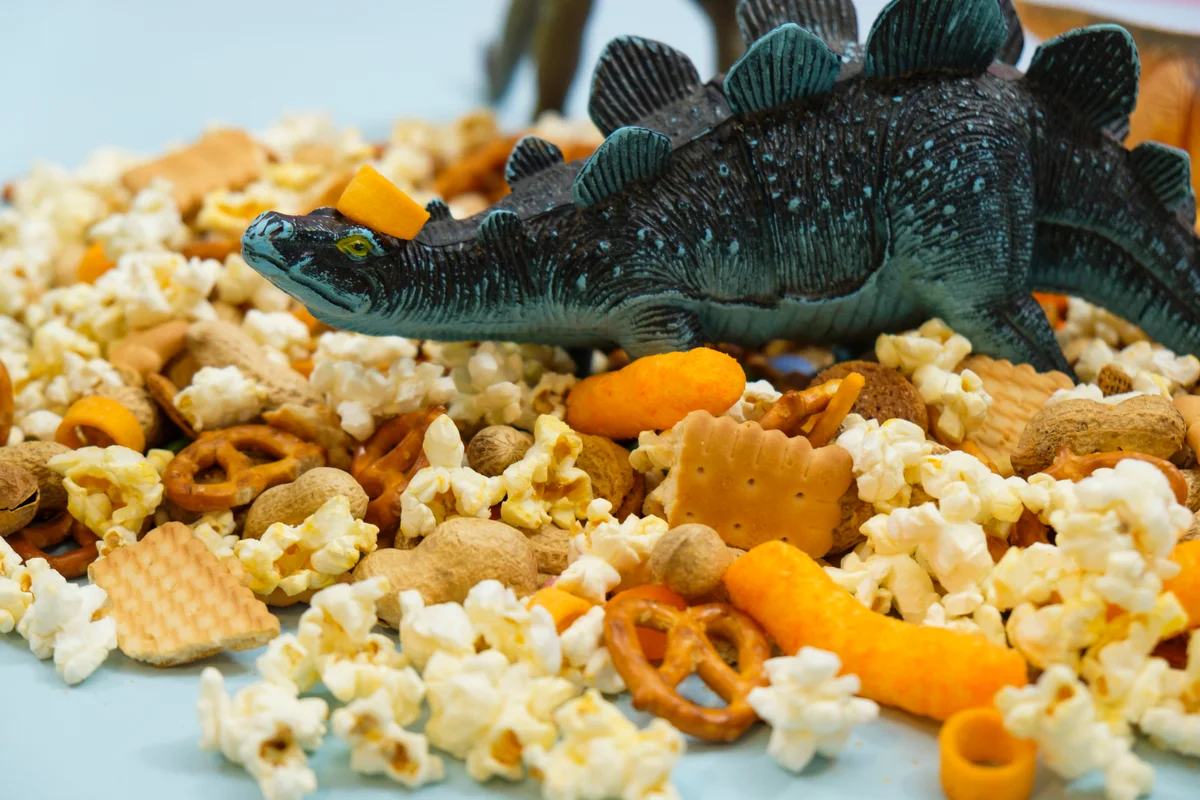 dinosaur toy on popcorn snack mix