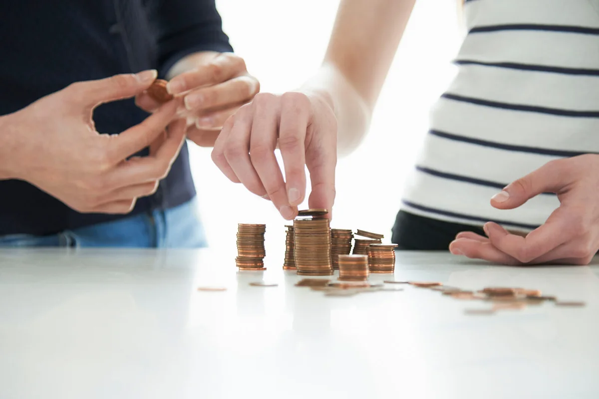 mother and daughter stacking coins at table