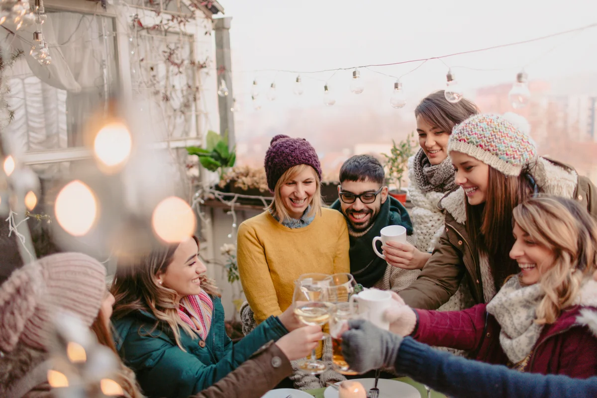 Group of friends toasting in a Christmas terrace party