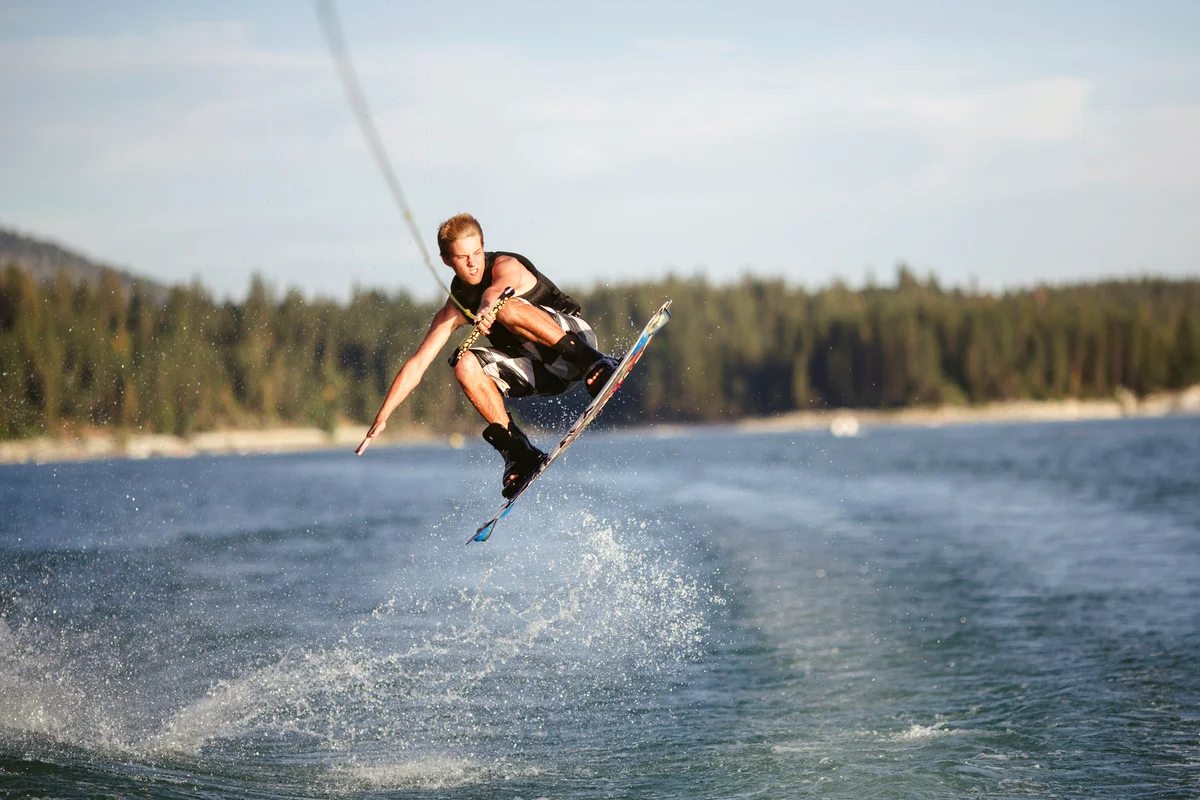 Young man in mid-air jump while wake boarding