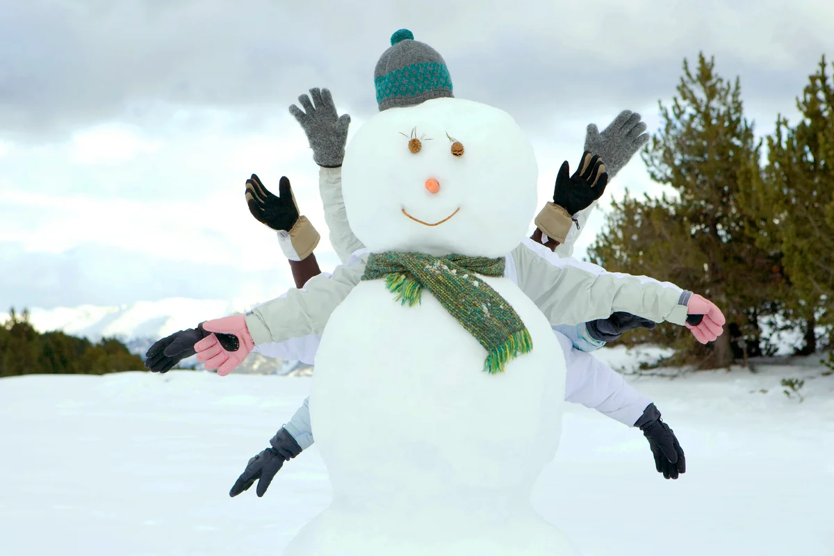Friends hiding behind snowman