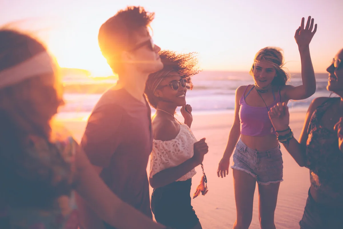 group of friends dancing together at a beachparty
