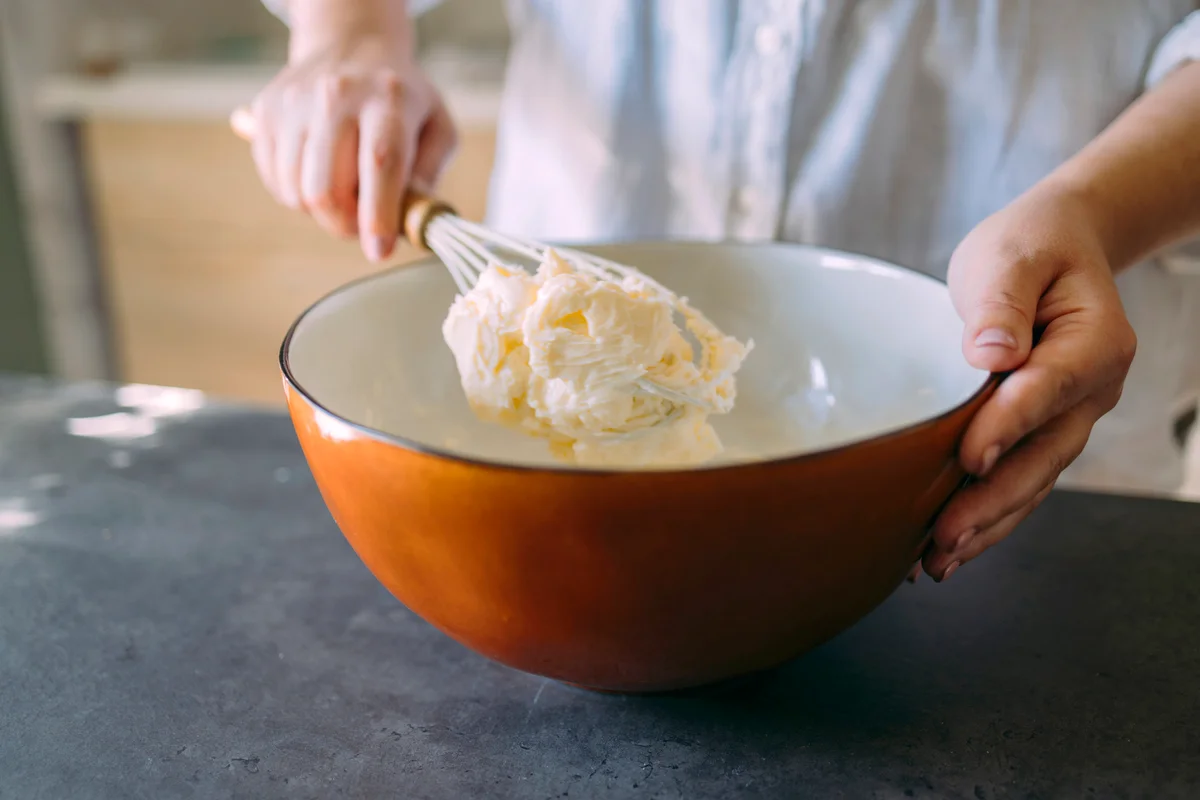 Female Baker Mixing Butter with a Whisk in a Domestic Kitchen
