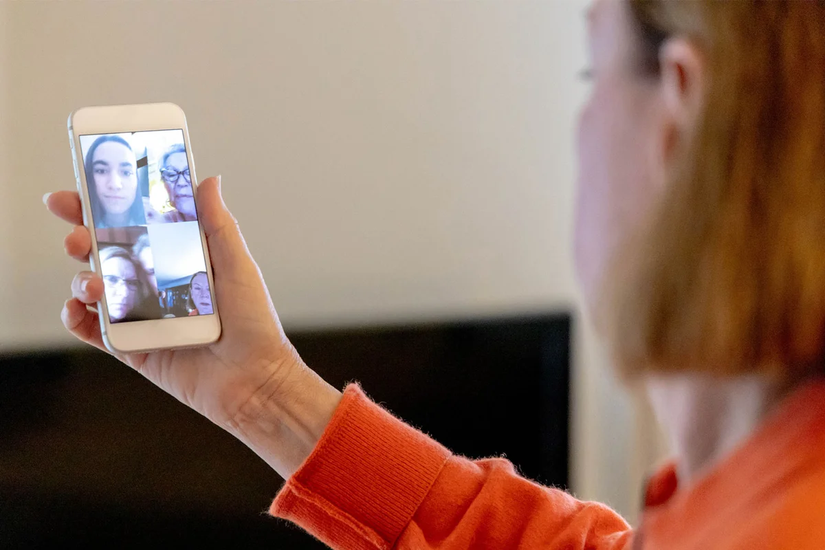 woman having group video chat on phone with online support group