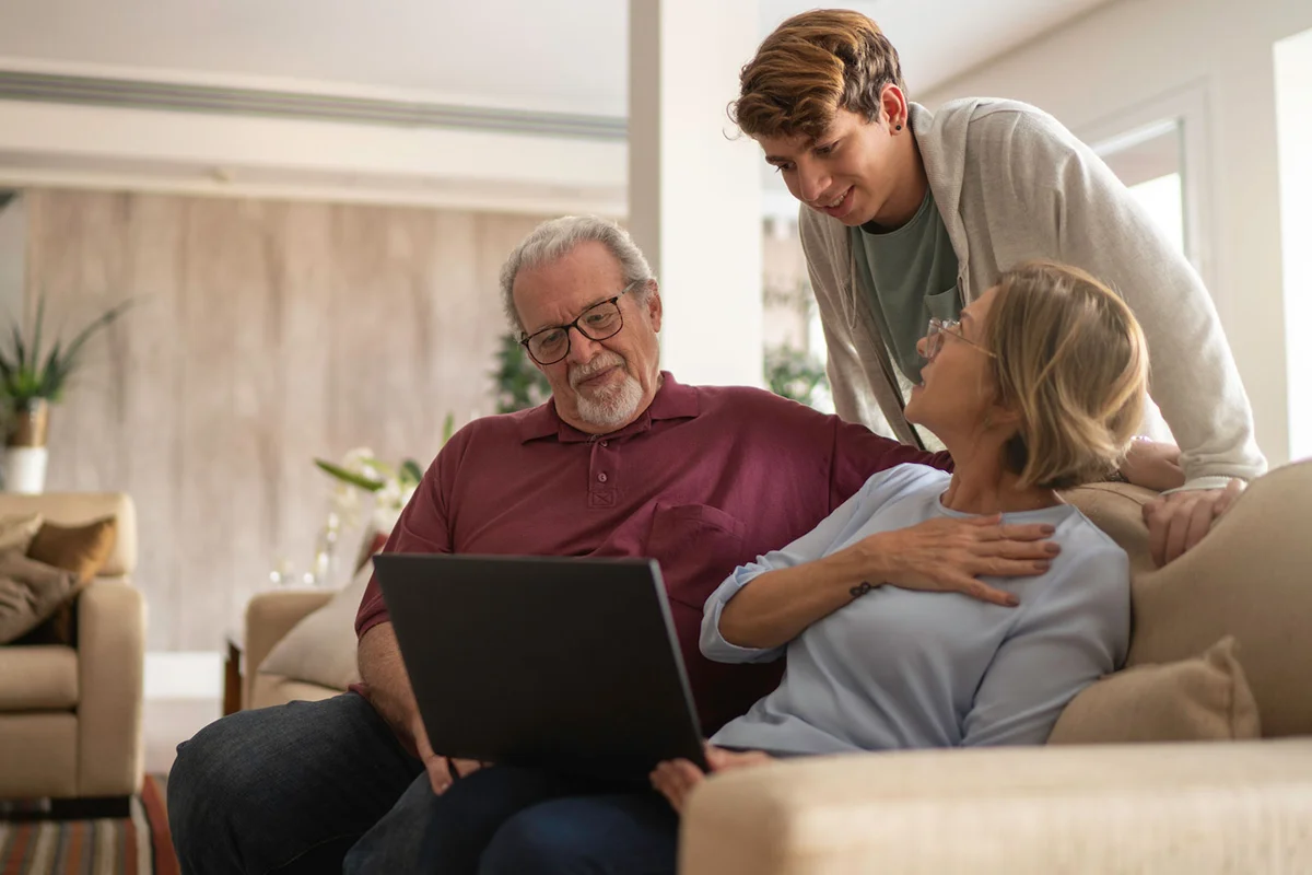 family watching online memorial together on laptop