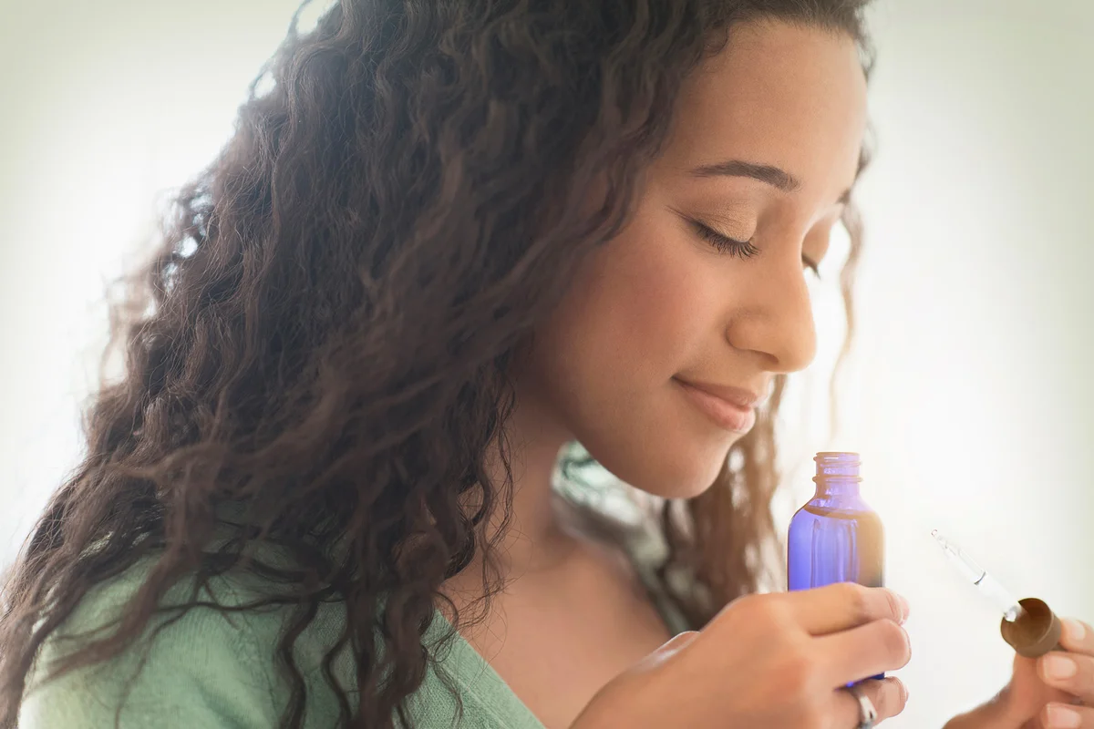 Woman smelling aromatherapy oil