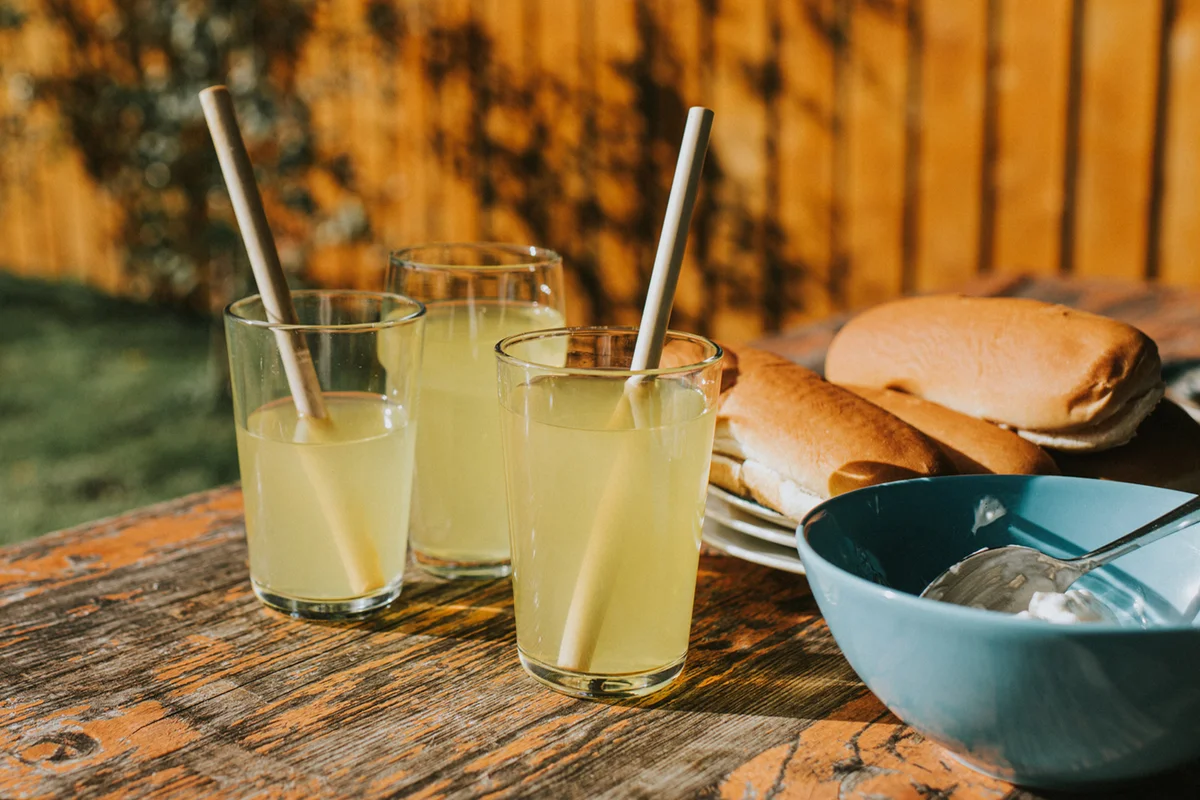 Juices in glasses with bamboo straws on a picnic table