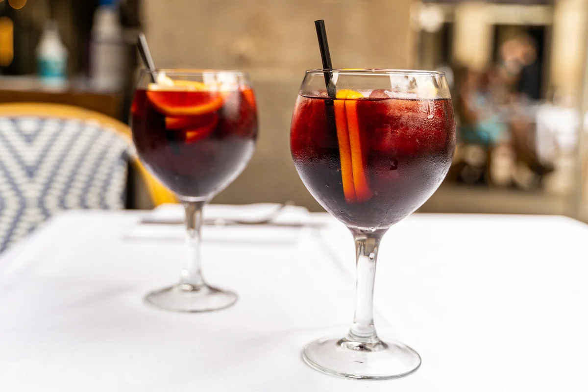 Two red sangria glasses on restaurant terrace table on sunny day