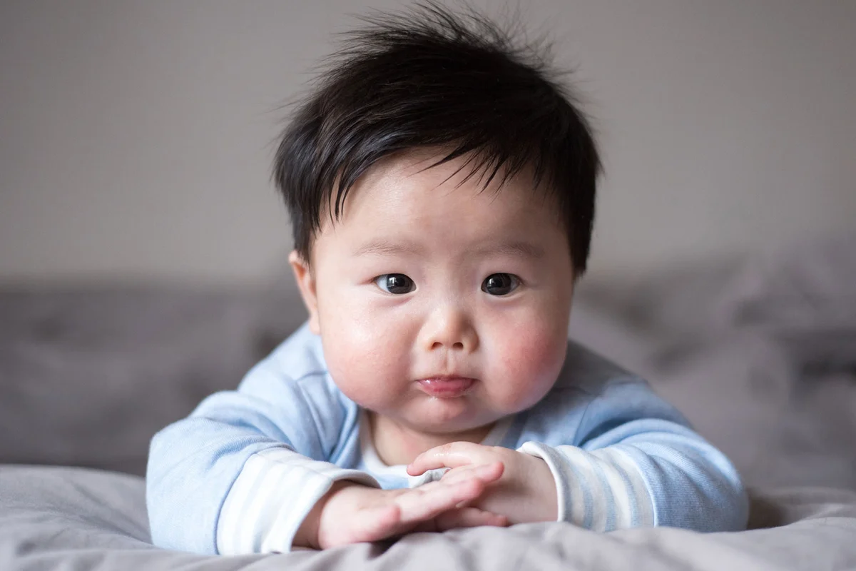 baby boy with short name on bed