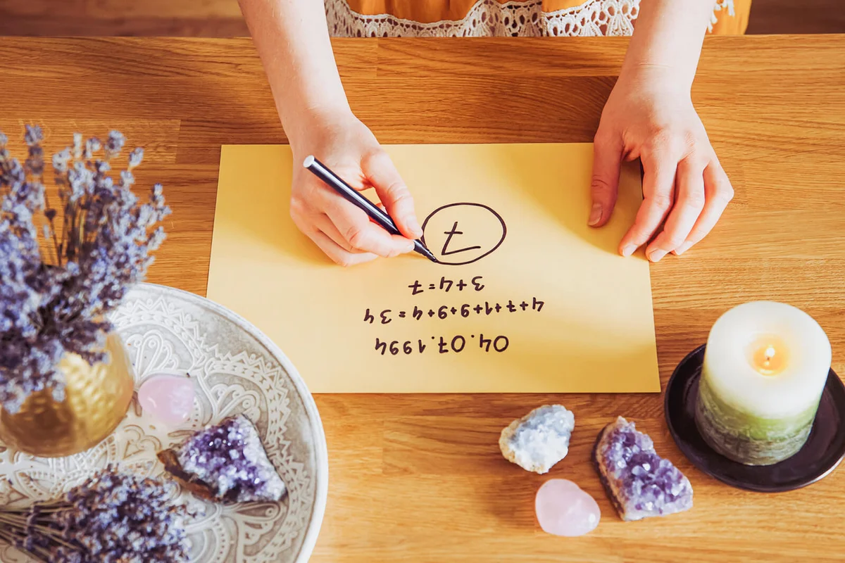 Top view of girl calculate Life path number on paper in home table