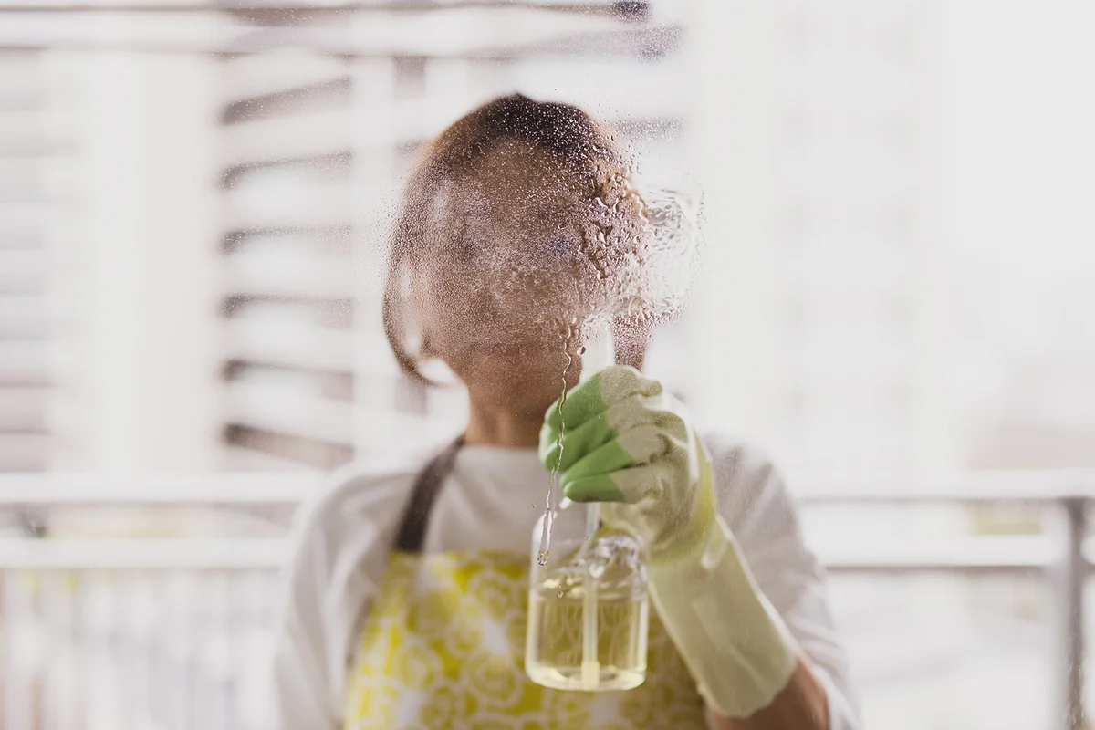 woman cleaning windows with lemon mix