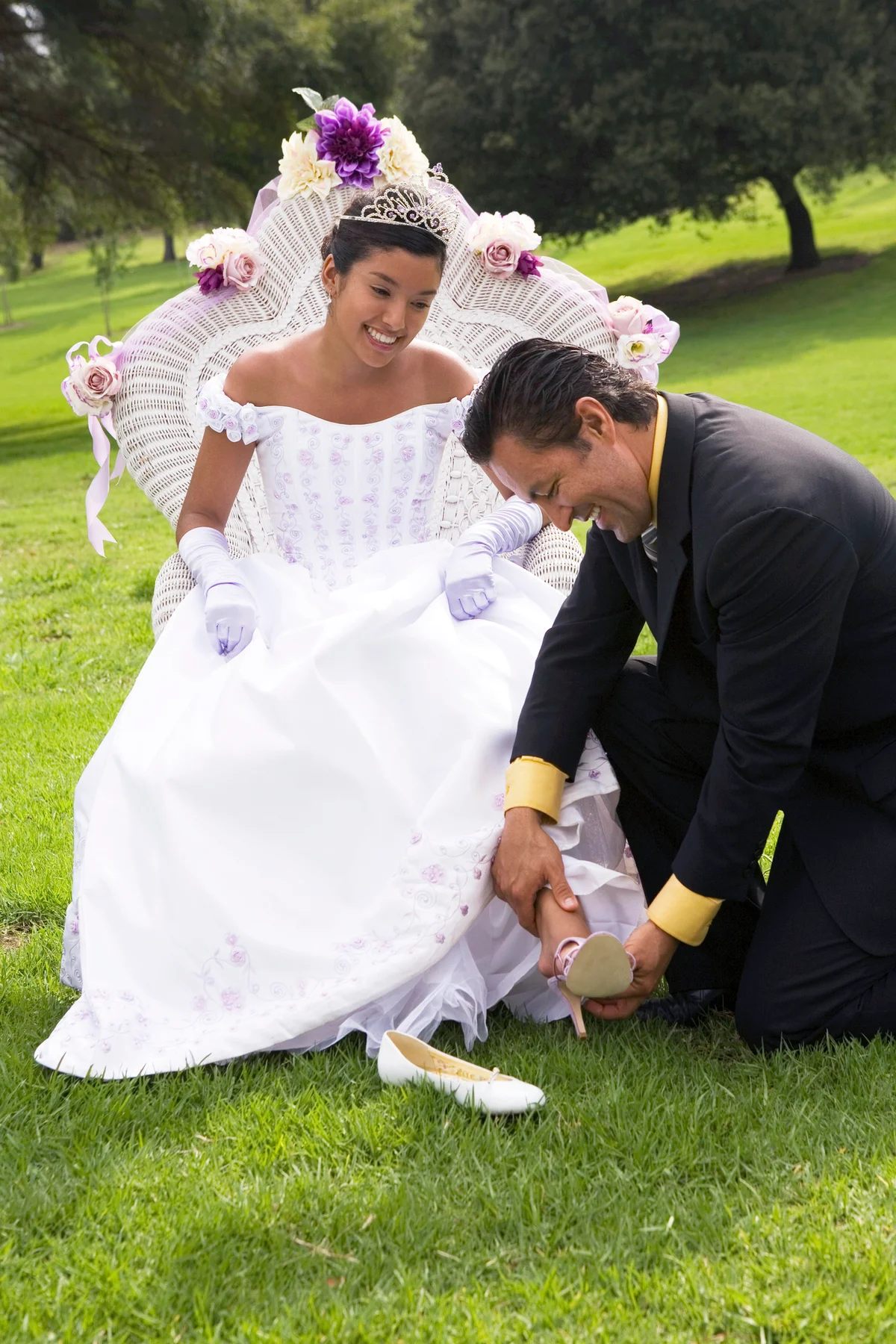 Father putting on teenage girls shoes at quinceanera