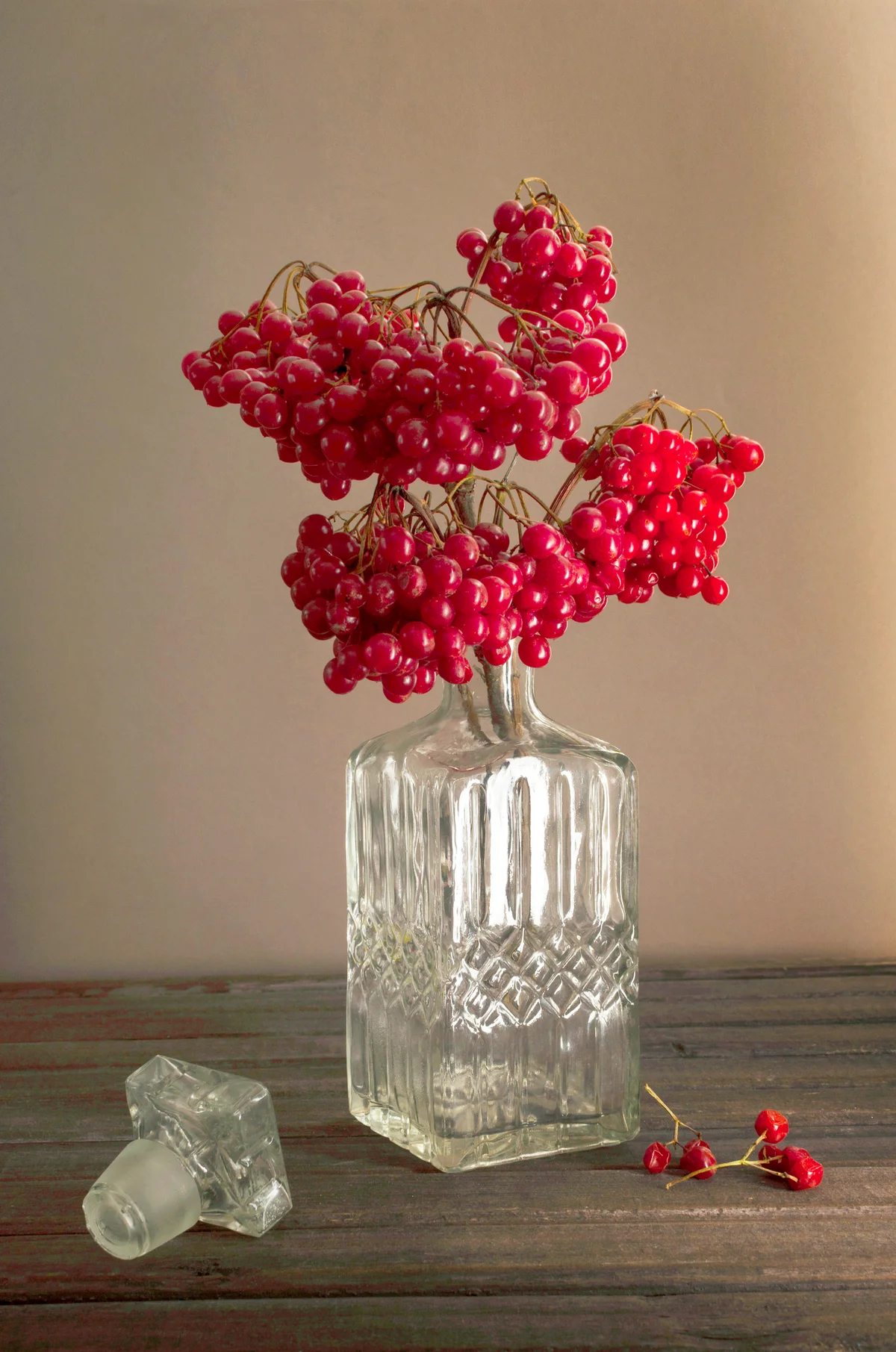 Glass decanter with viburnum branch in it