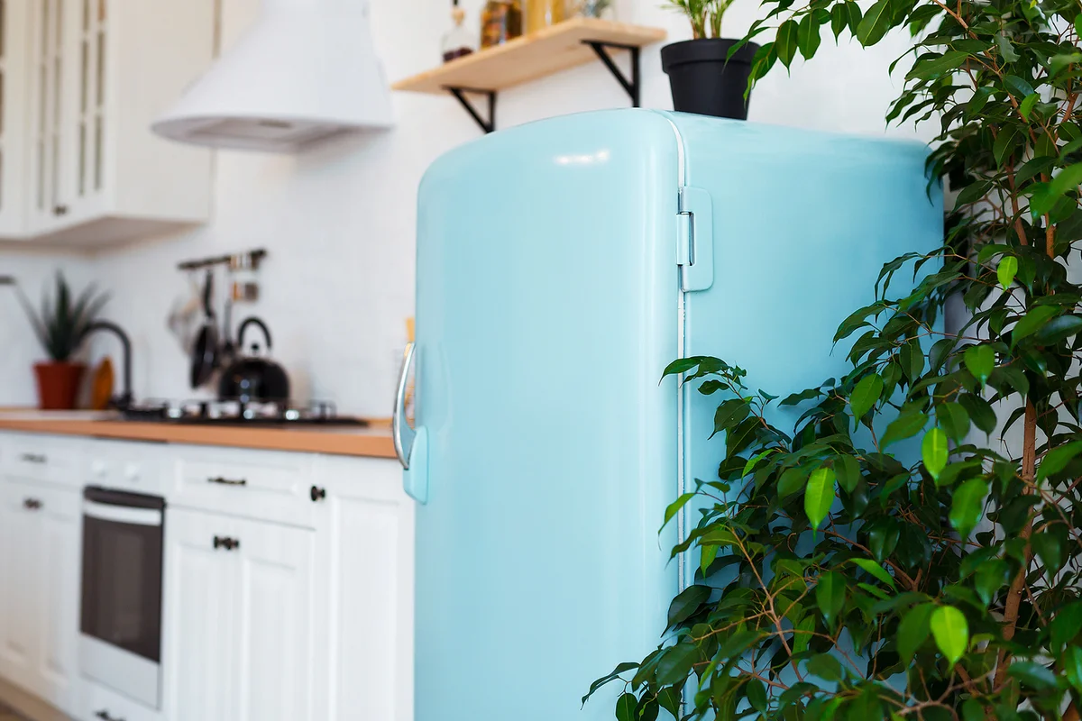 Kitchen interior in white textured colors with blue modern retro fridge
