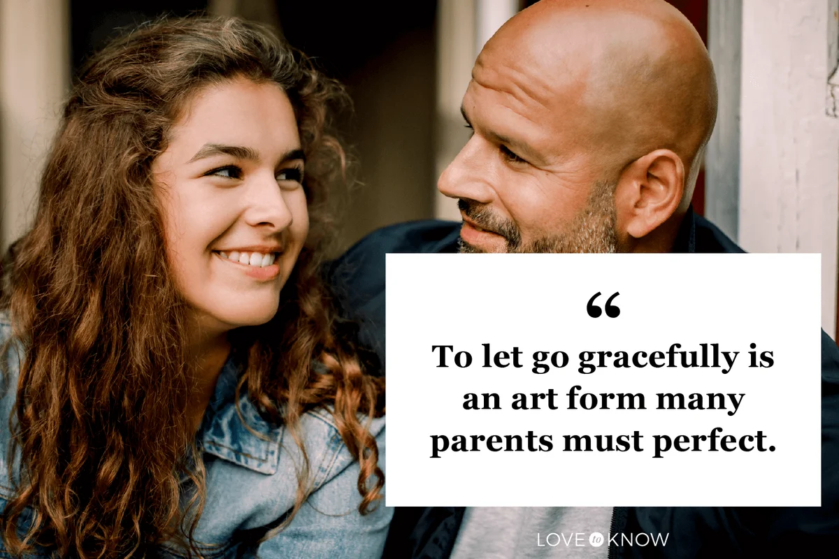 Smiling teenager looking at father while talking outdoors