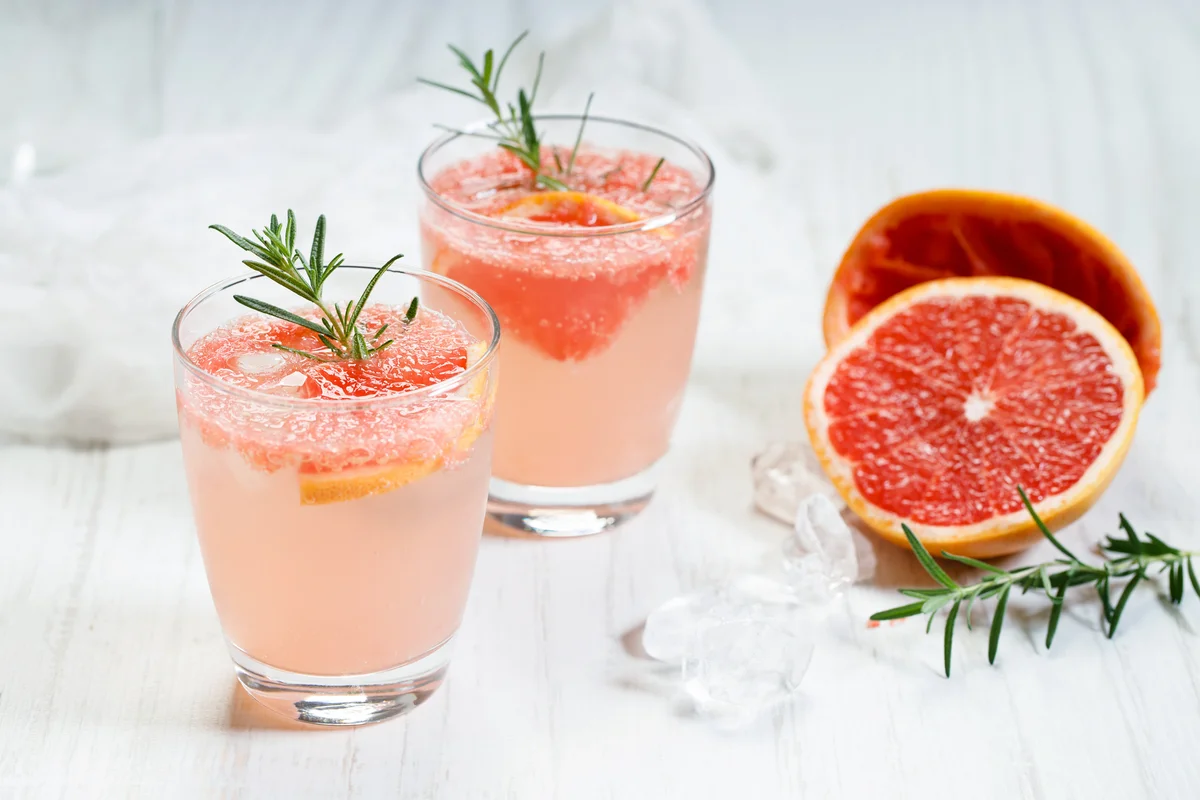 Two paloma cocktails with ice and rosemary
