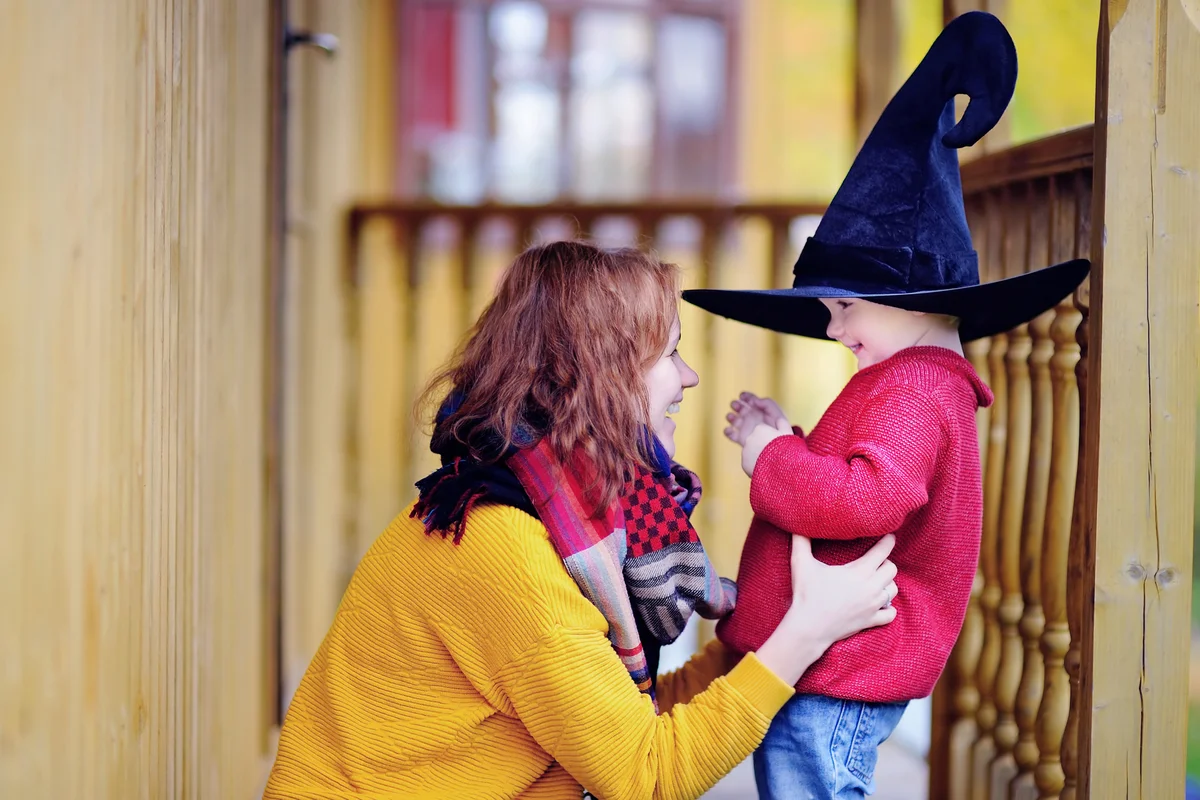 Cute happy little wizard and his young mother outdoors