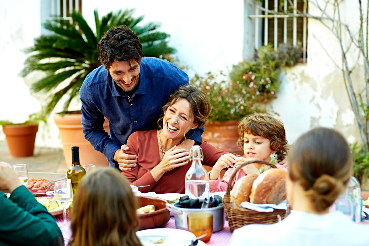 happy couple having dinner outside with family
