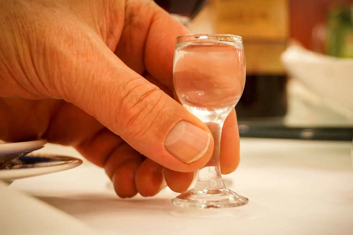 Tiny Baijiu liqueur glass in hand