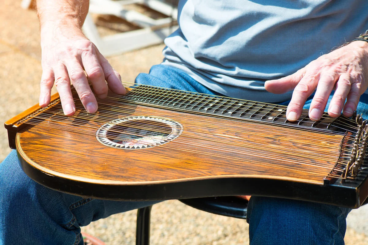 Man plays an Autoharp In outdoor show