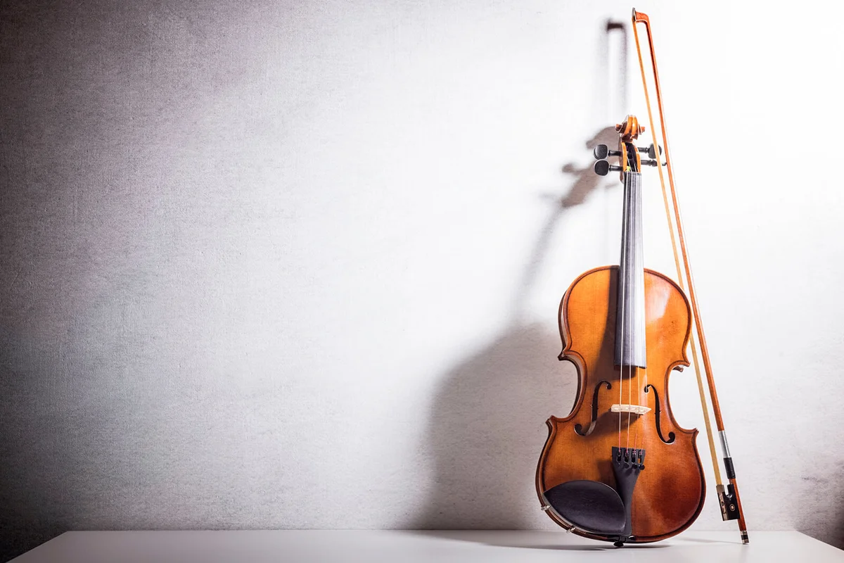 Violin leaning against a blank wall