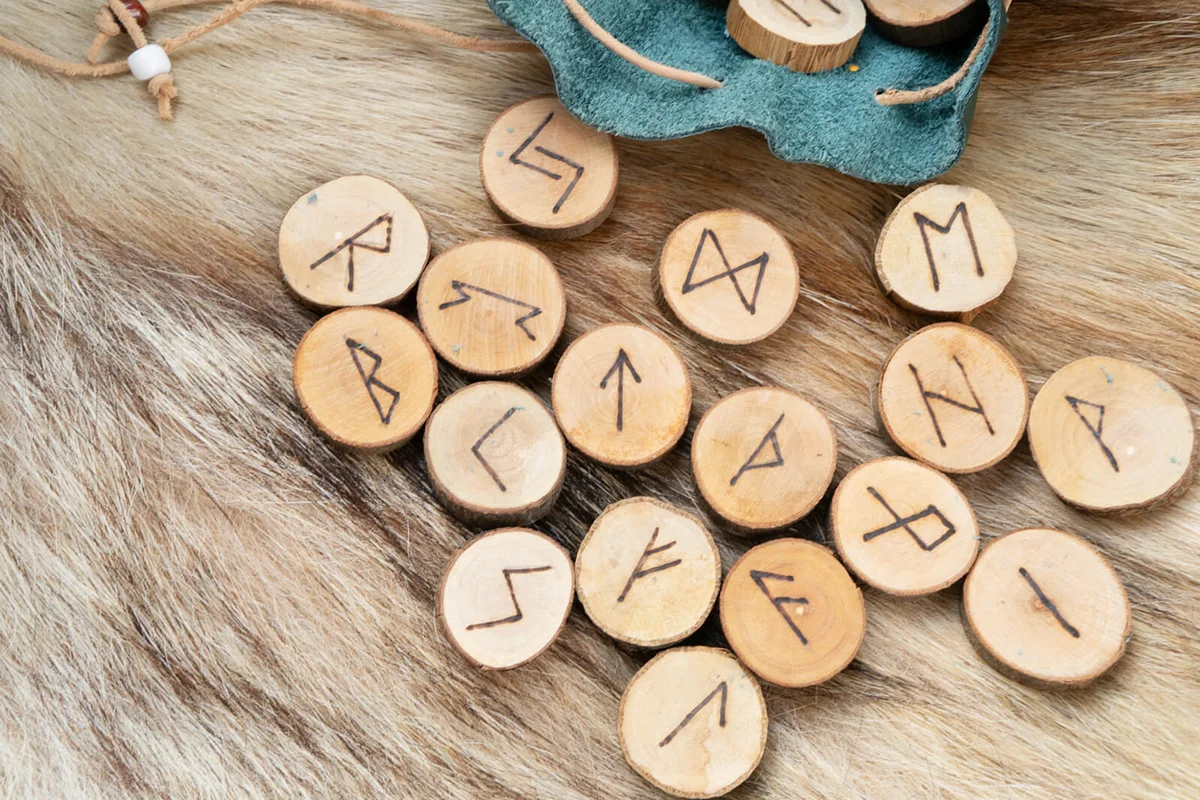 Handmade runes for fortunetelling in leather bag over wolf fur