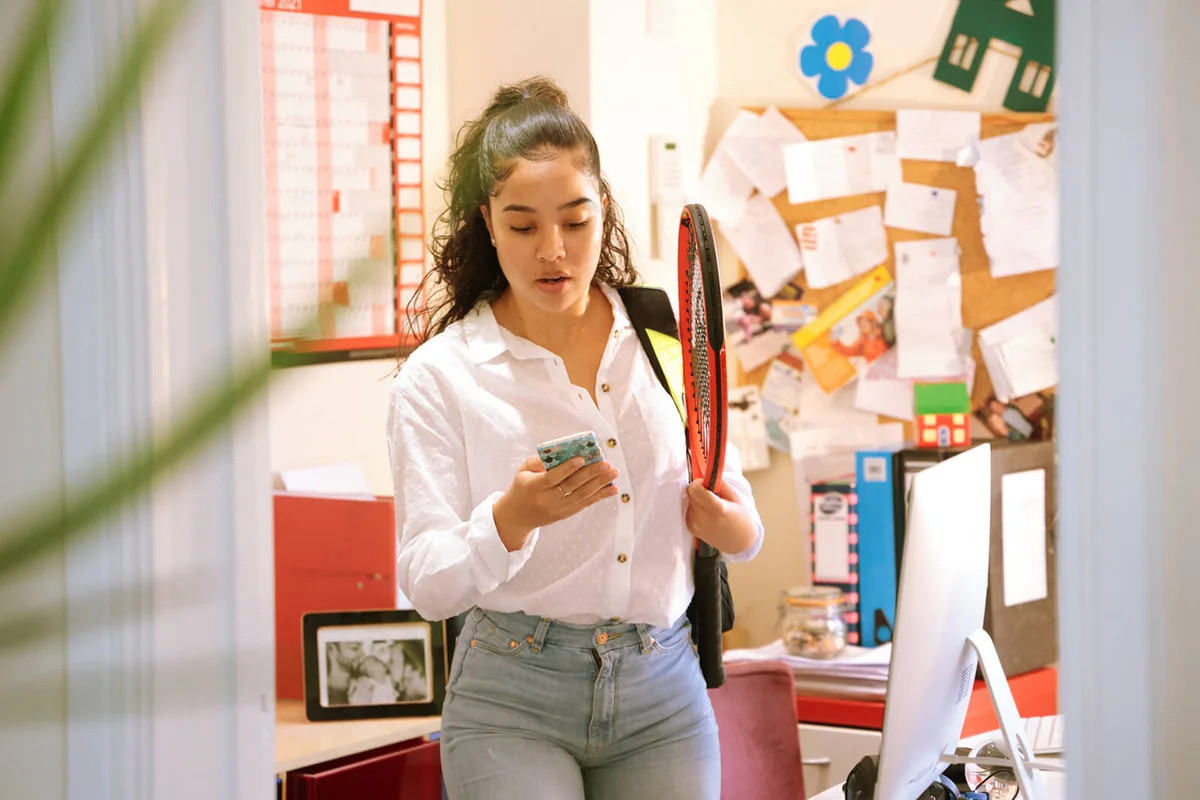 Woman leaving office with tennis equipment