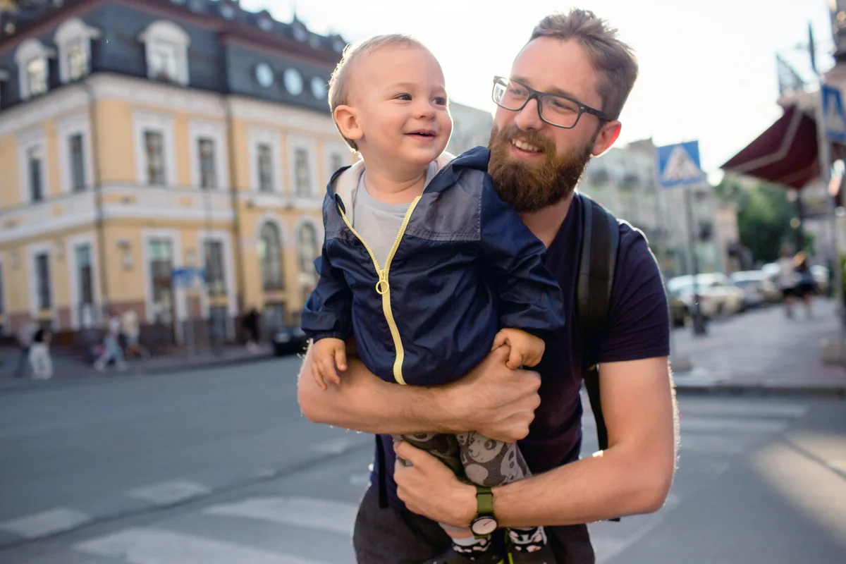 Young bearded man holds his little smiling son