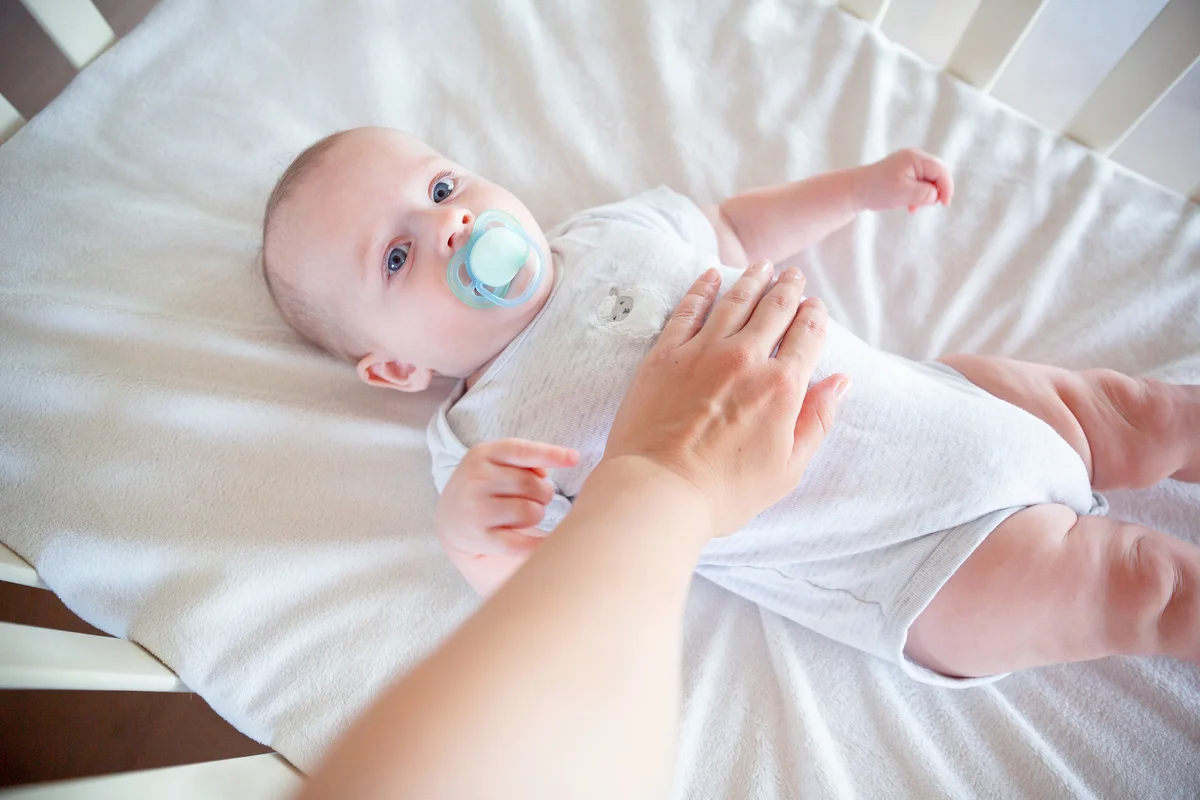 Mother holds her hand on the belly of the baby