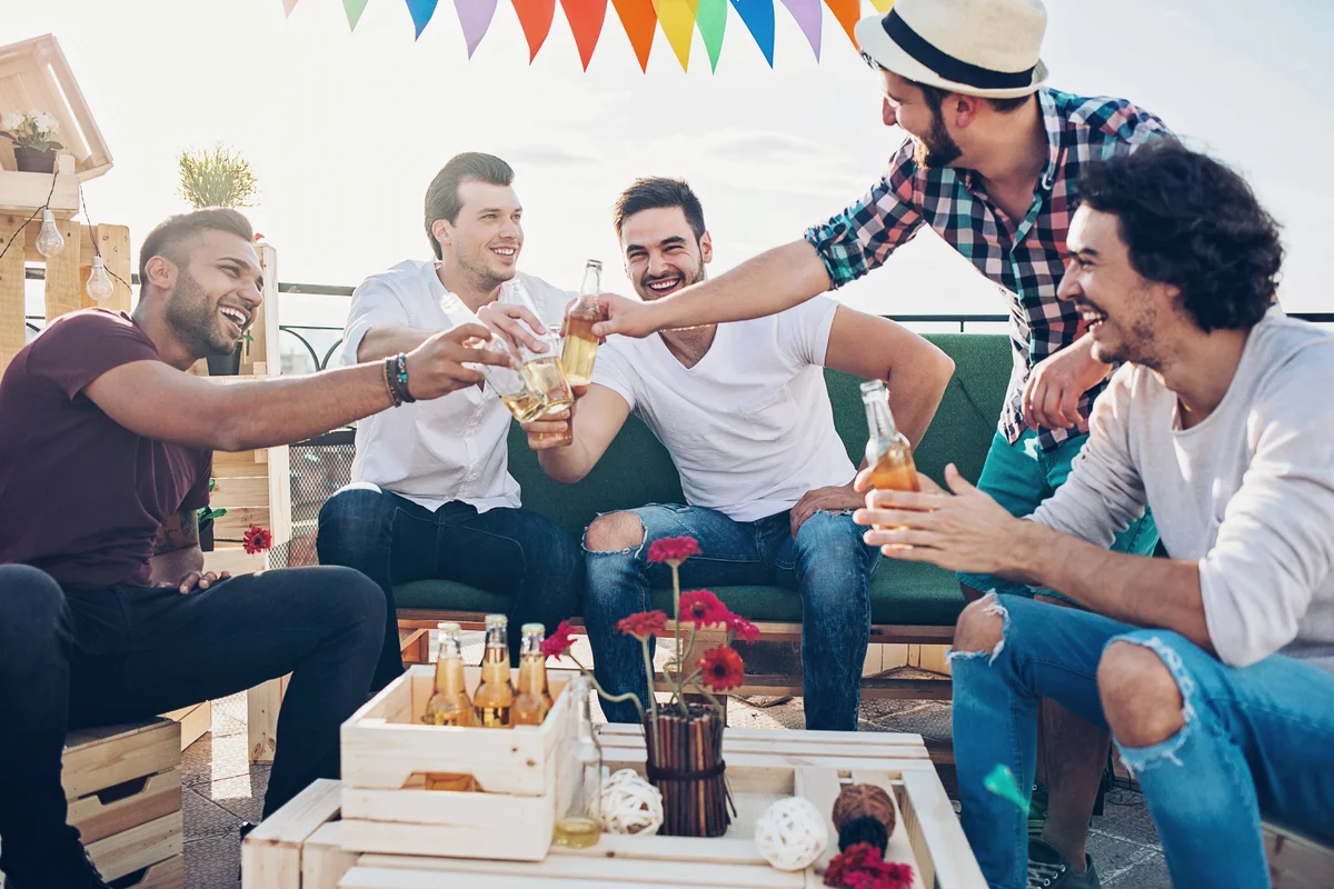 Group of young men chatting and drinking beer on bachelor party