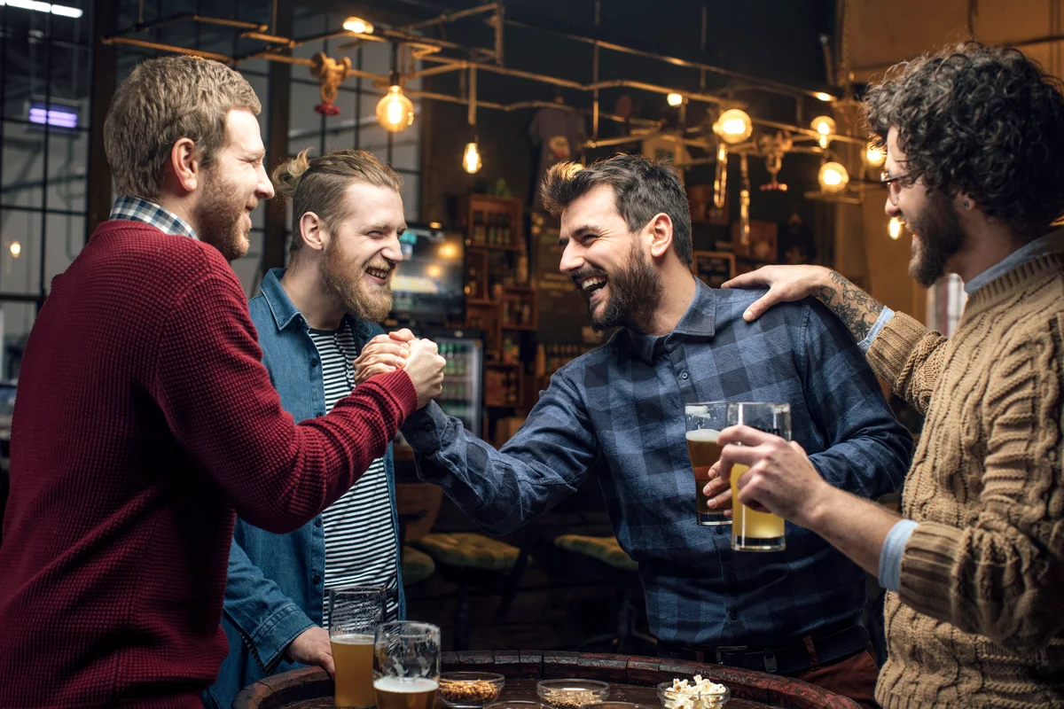 Group of friends drinking beer at the pub together