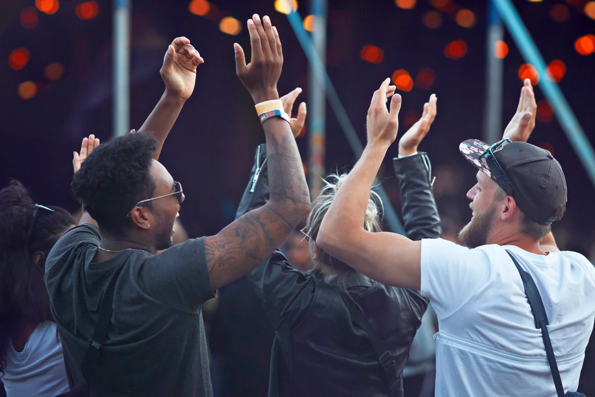 Friends clapping together at concert