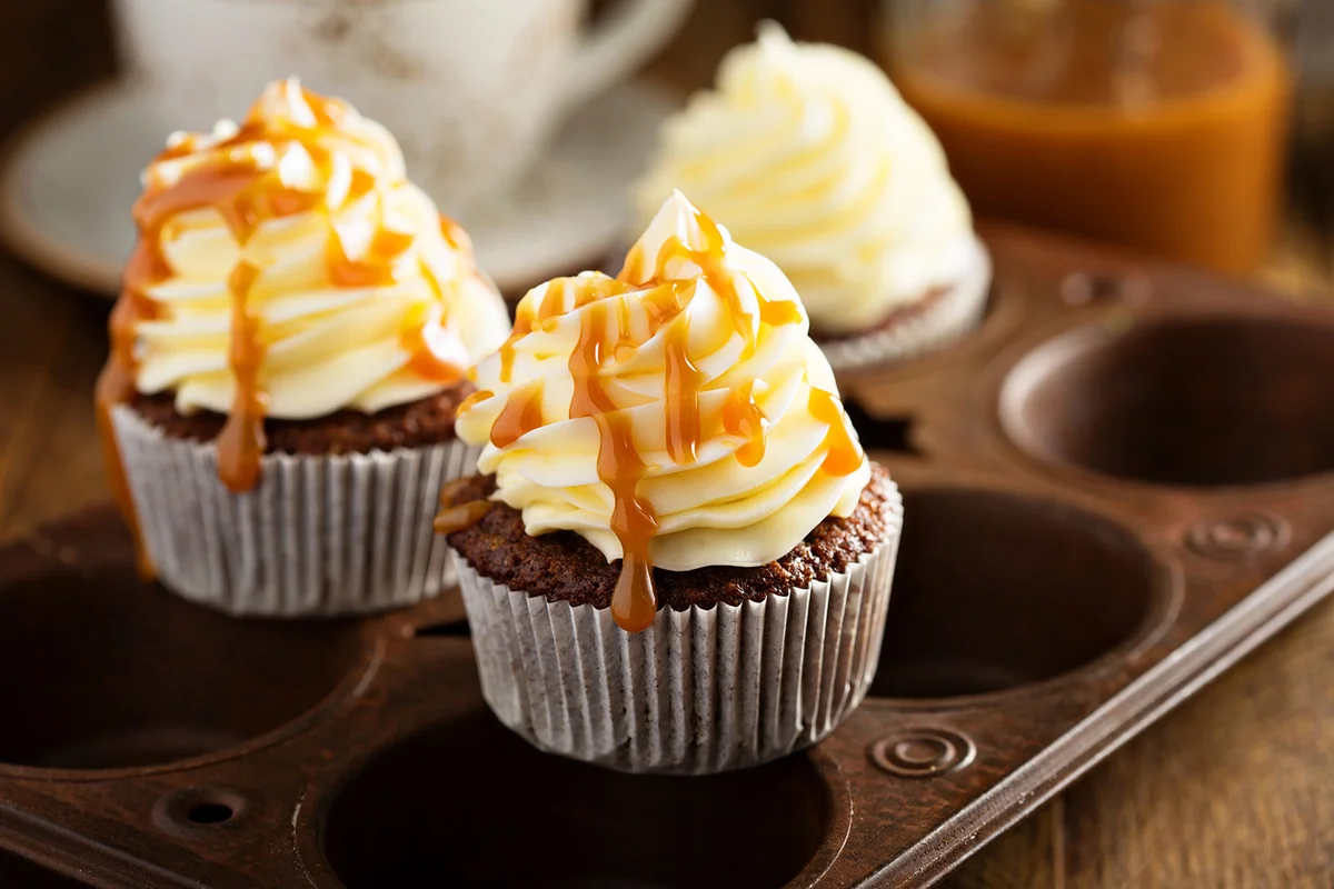 Homemade cupcakes with caramel syrup and cream cheese frosting