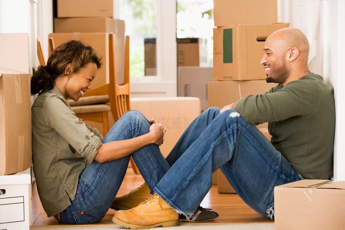 couple having fun taking break with moving boxes