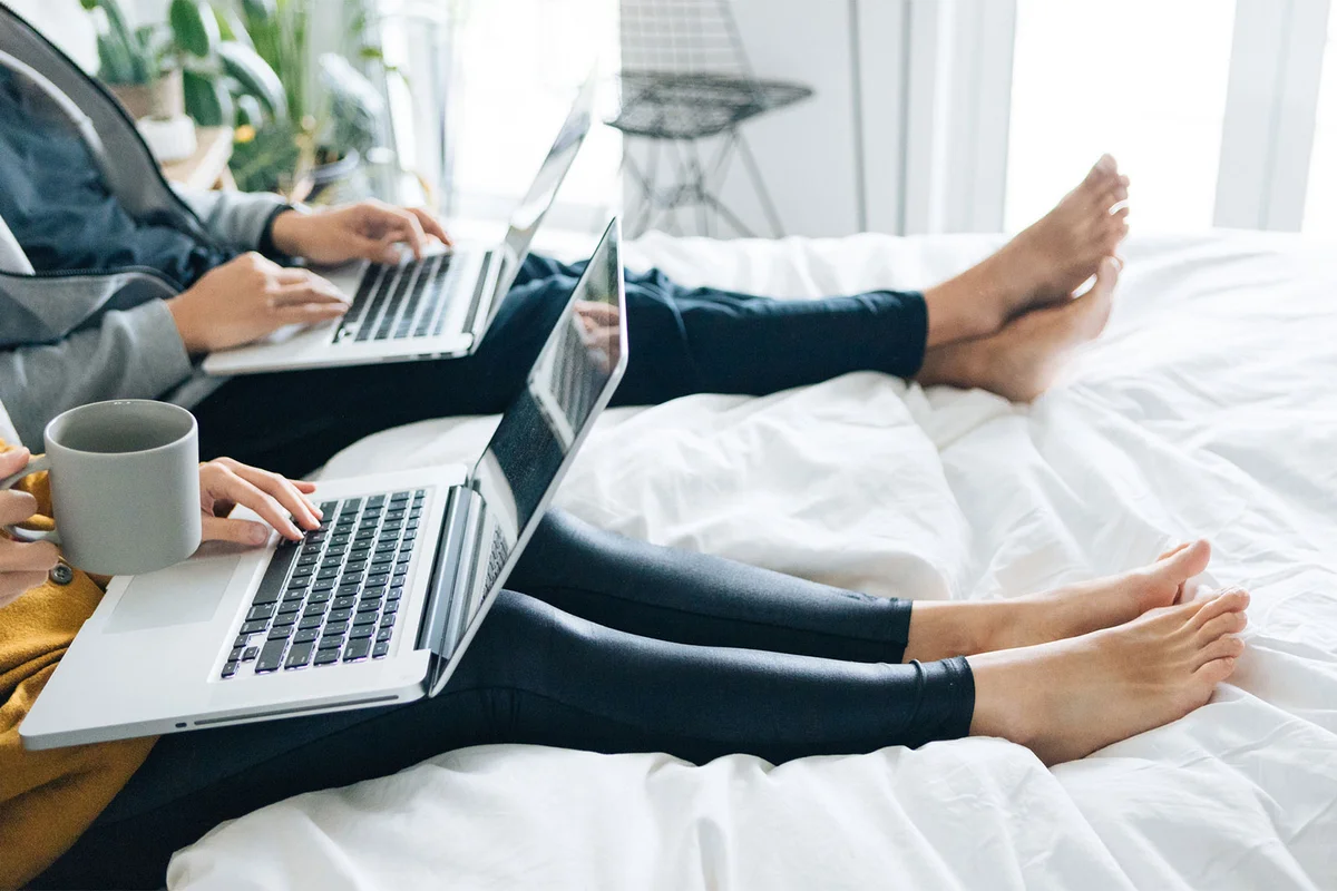 couple in bed working on laptop computers