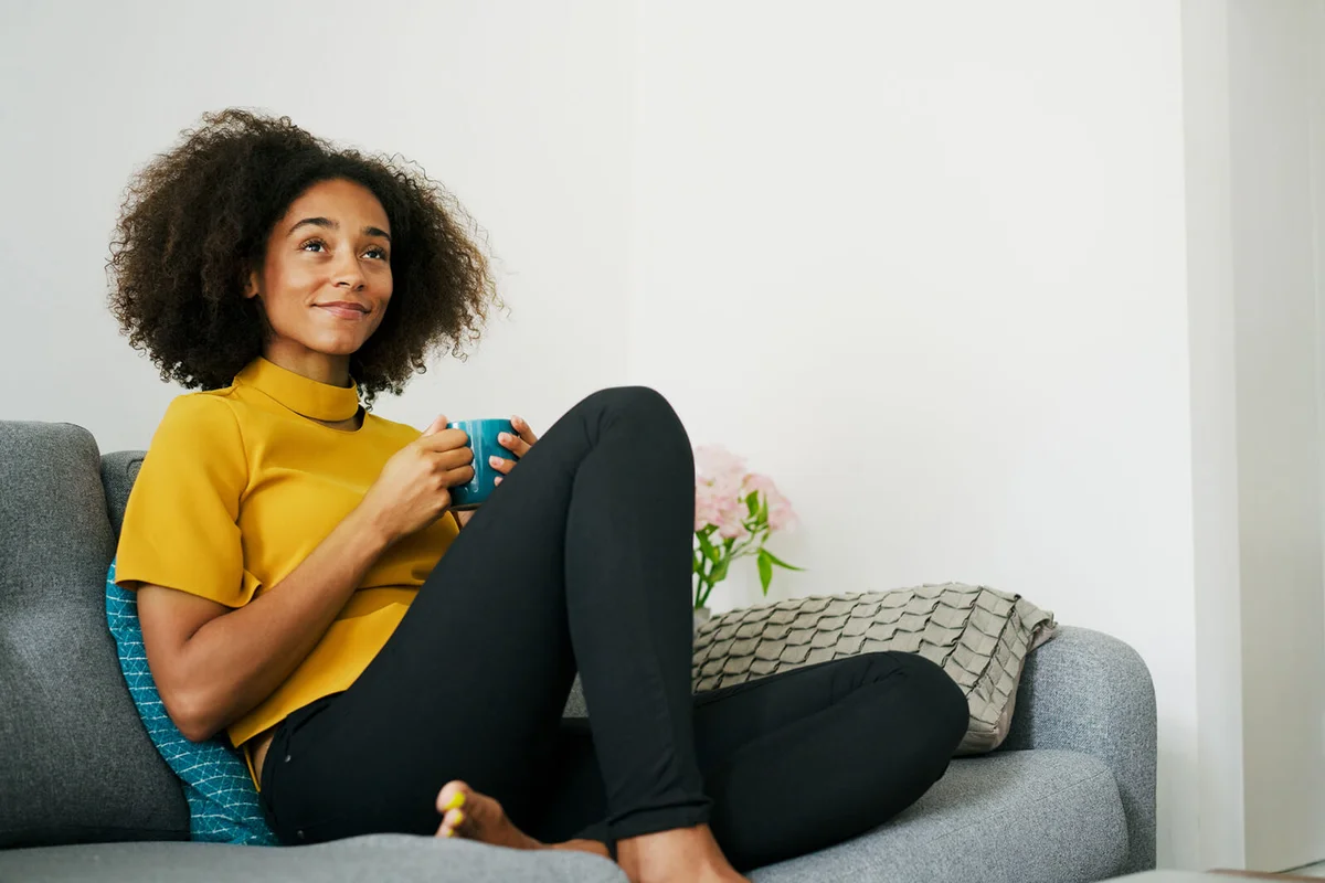Woman relaxing on sofa with hot drink