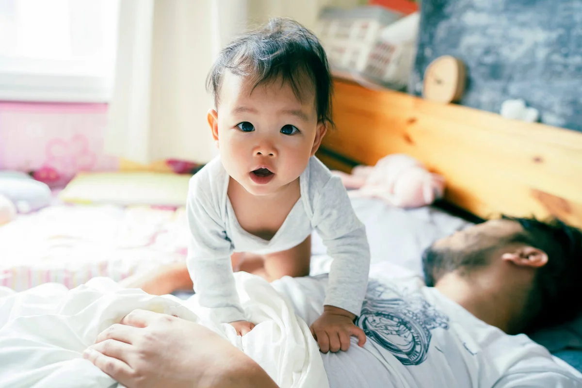 baby wake up early before daddy and playful on the bed