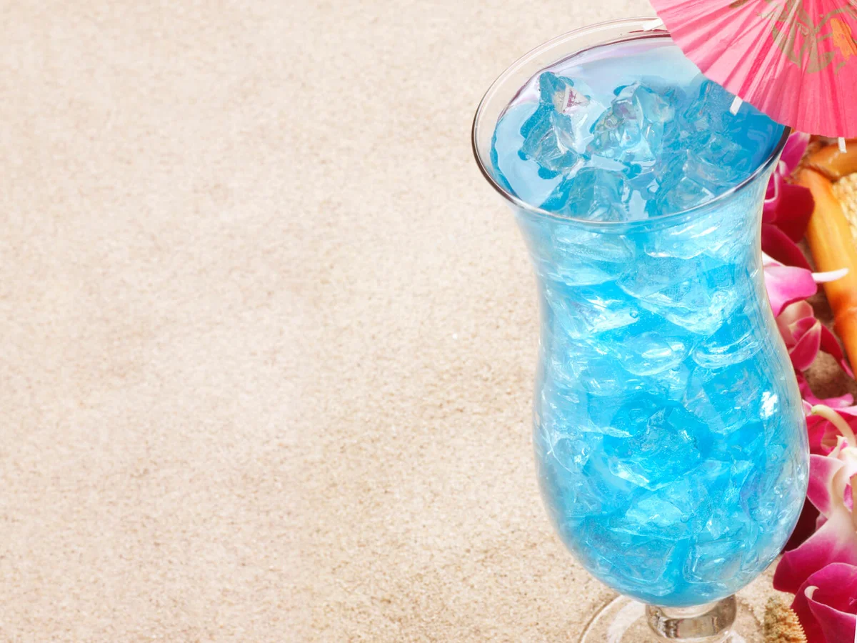 A Blue Hawaiian tropical drink on the beach