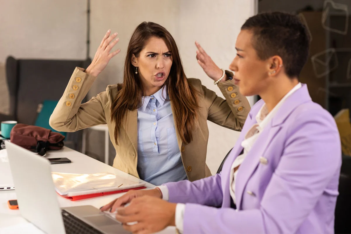 angry business woman shouting at coworker