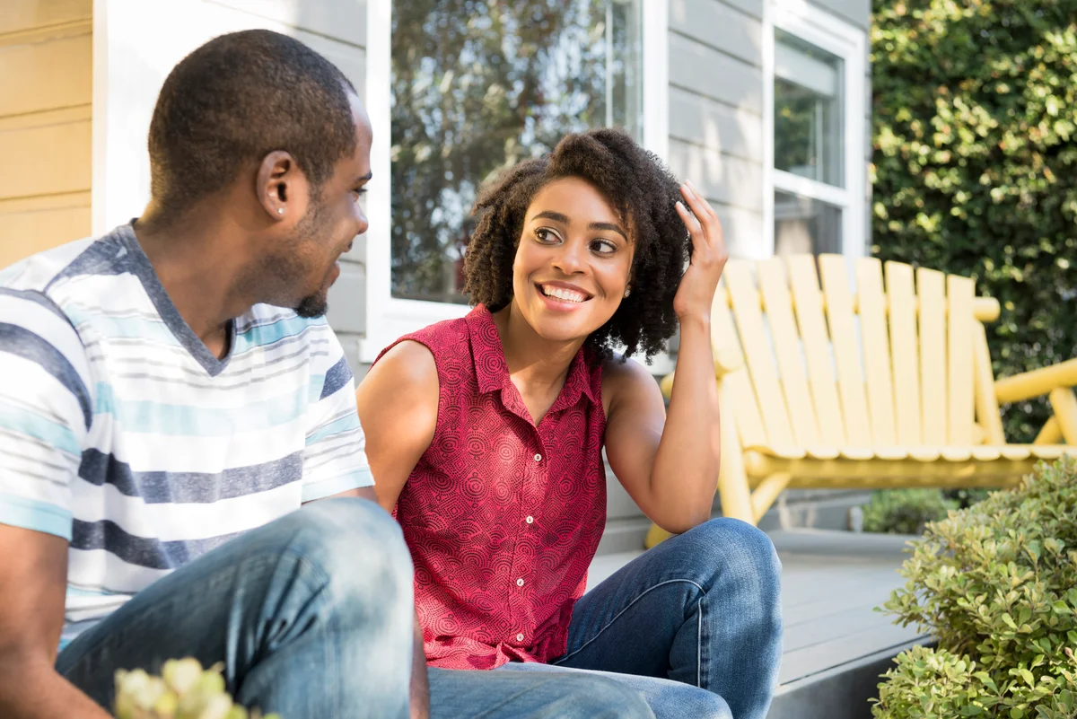 romantic couple sitting on front porch of house