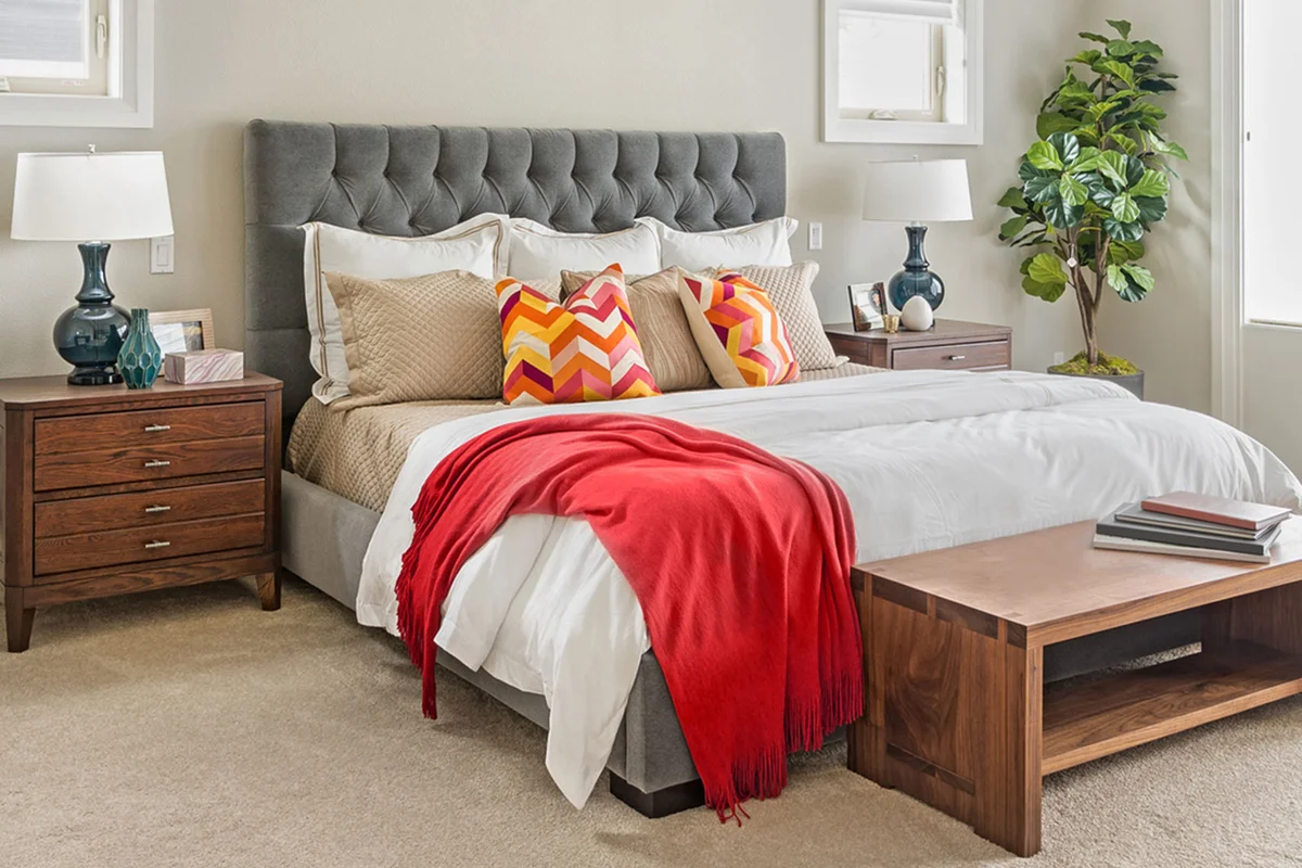 feng shui bedroom with red blanket and a pair of lamps