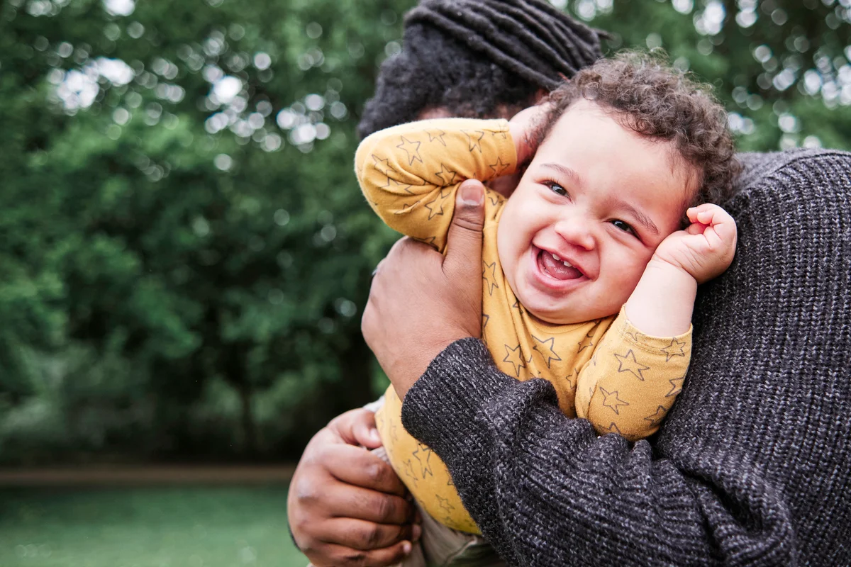 Cheerful son playing with father at park
