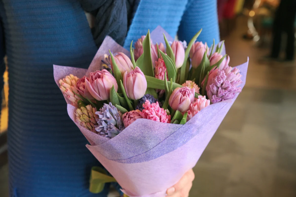 Bouquet of tulips and irises in the hands