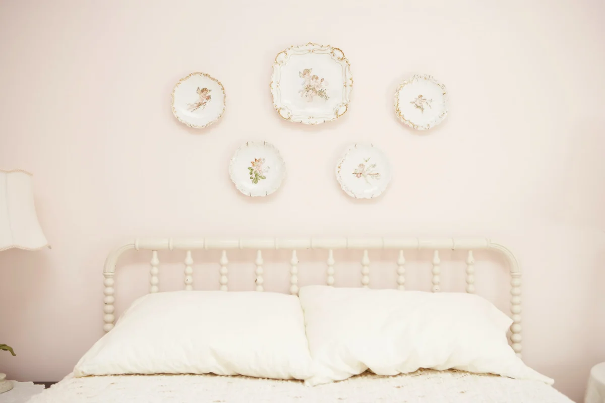 Bedroom with porcelain hanging on wall above bed