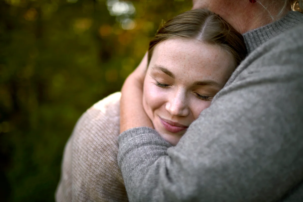 Grandmother embracing adult granddaughter in garden