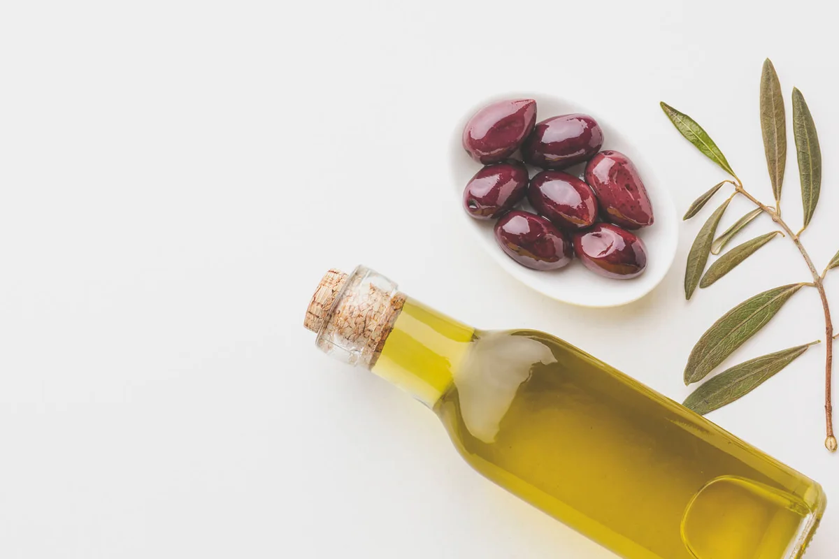 Olive oil bottle with leaves purple olives with copy space