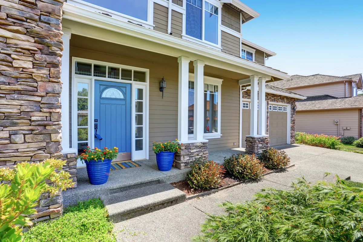American house with blue door and gorgeous outdoor landscape