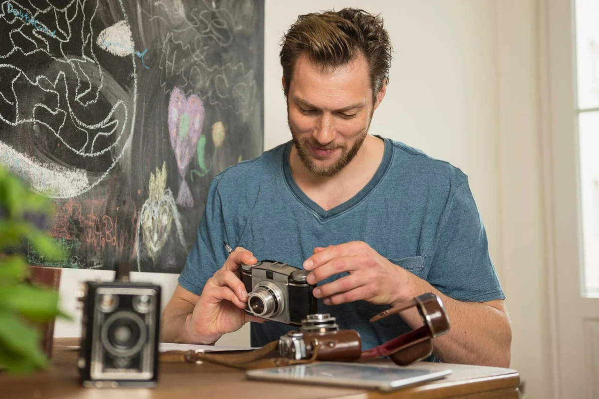 man evaluating condition of antique clock collection