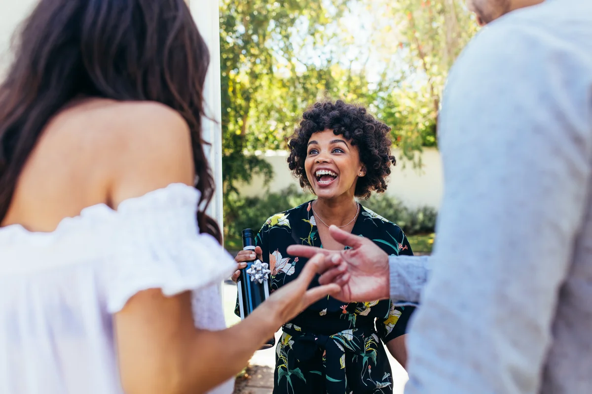 friend bringing wine at housewarming party