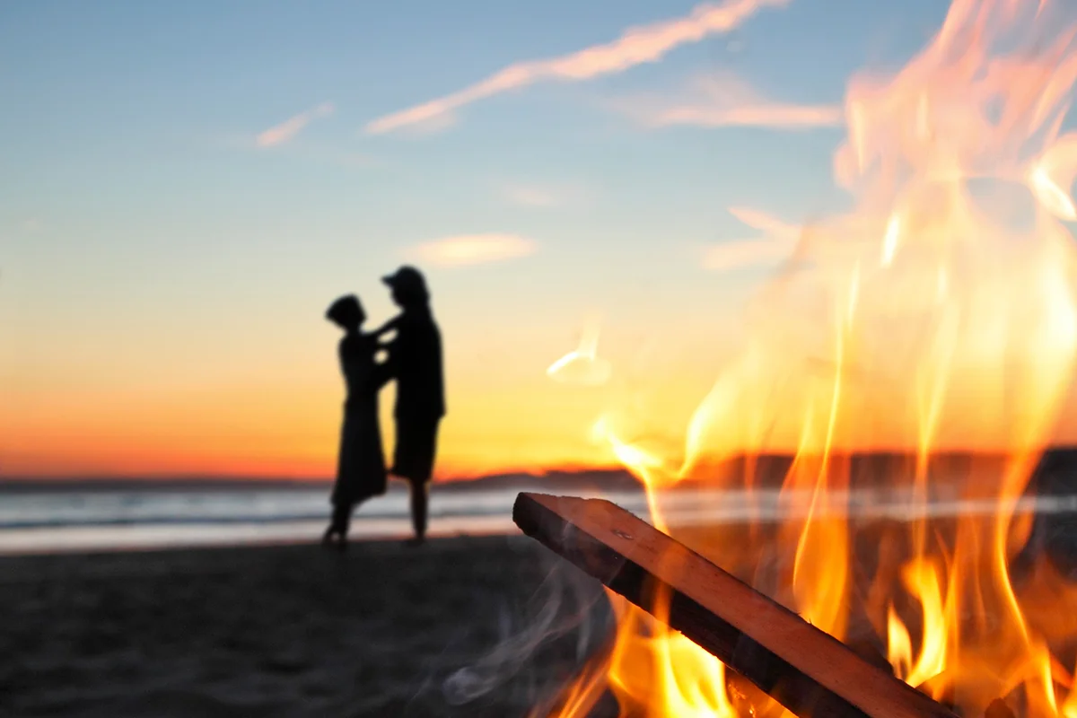 Romantic couple, beach, fire